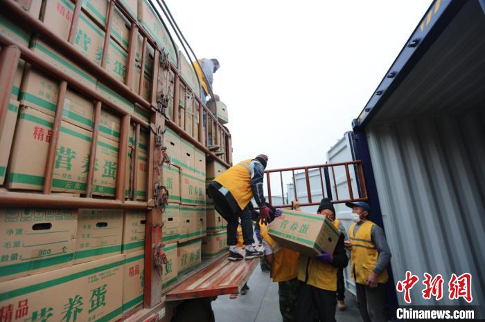 圖為鐵路裝卸作業(yè)人員正在將云南特色農(nóng)產(chǎn)品裝入集裝箱?！詈?攝