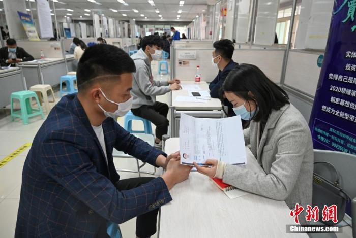 4月14日，招聘者在查看求職者簡(jiǎn)歷。<a target='_blank'  data-cke-saved- >中新社</a>記者 王剛 攝