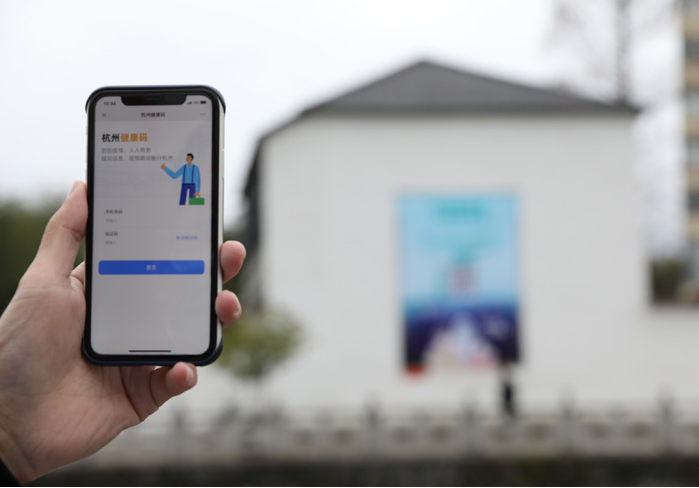 在浙江省杭州市臨安區(qū)天目山鎮(zhèn)，一名居民在“杭州健康碼”海報(bào)上掃碼申領(lǐng)個(gè)人二維碼。新華社發(fā)