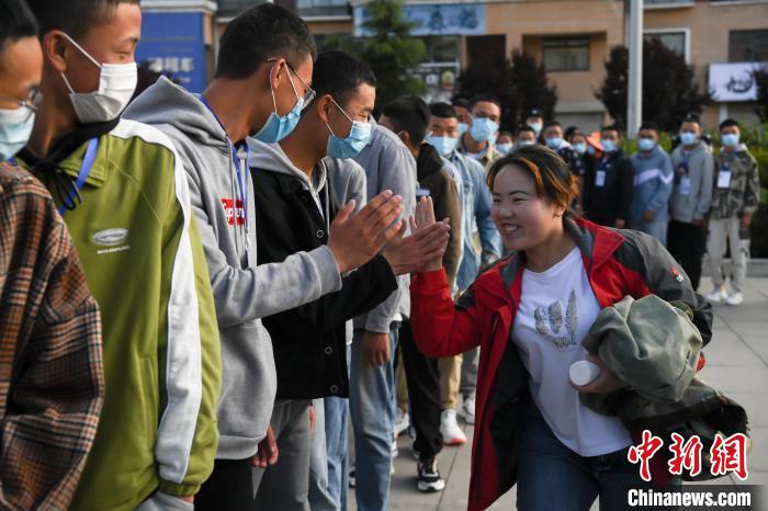 7月7日，拉薩三高考點外，領隊老師與考生擊掌鼓勁加油。　何蓬磊 攝